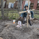 A young kid gives an offering of food to the grave of a woman in the town of Bucha, on the outskirts of Kyiv, on April 4, 2022.